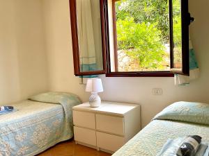 a bedroom with two twin beds and a window at Villa a San Teodoro in San Teodoro