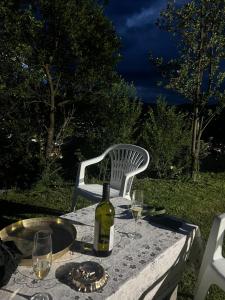 a table with a bottle of wine and a chair at Obrov Biker Friendly in Bijelo Polje