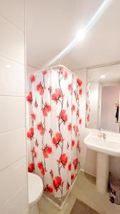 uma casa de banho com uma cortina de chuveiro com flores vermelhas em Vista panoramica increible em Viña del Mar