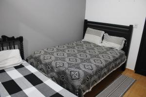 1 cama con edredón blanco y negro y 2 almohadas en Hotel Cristo Rei, en Conceição da Aparecida
