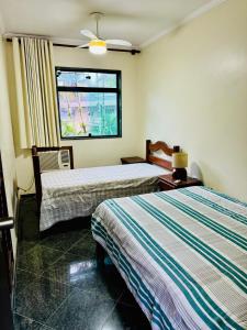 Habitación de hotel con 2 camas y ventana en Tombo Beach Hostel & Pousada, en Guarujá
