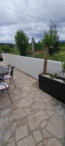 a patio with a table and chairs and a wall at Carlana House in Paredes de Coura