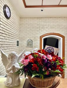 Un cesto di fiori e una statua di un angelo. di Hotel Korona a Kropyvnyc'kyj