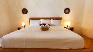 1 dormitorio con 1 cama blanca grande y 2 lámparas en HOTEL NIETO MOMPOX, ubicado en el corazón del centro histórico, frente al rio magdalena en zona de malecón, en Mompox