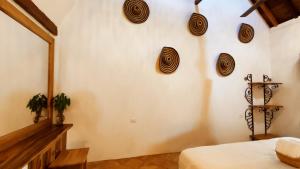 um quarto com uma parede branca com decorações na parede em HOTEL NIETO MOMPOX, ubicado en el corazón del centro histórico, frente al rio magdalena en zona de malecón em Santa Cruz de Mompox