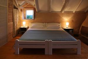 a bedroom with a large bed with two lamps on tables at Stonehome Pojata in Rušići