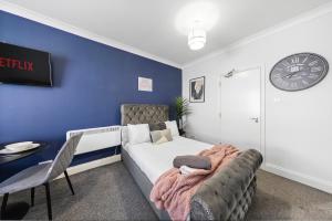 a bedroom with a bed and a clock on the wall at Chic Flat in Medway Comfort & Style in Chatham