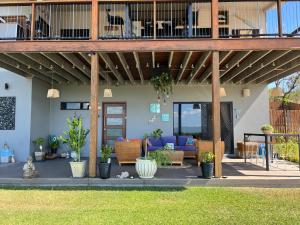 a house with a deck with a patio at Bowen Sunrise Retreat Homestay in Bowen