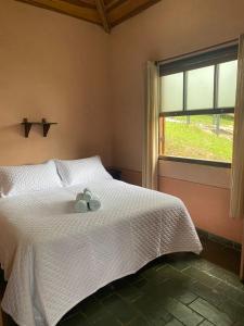 1 dormitorio con 1 cama con 2 toallas en Estrela da Serra Hotel Fazenda, en Santo Antônio do Pinhal