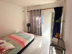 a bedroom with a bed and a window and a chair at Casa Colibri Palomino in Palomino