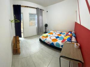 1 dormitorio con 1 cama con un edredón colorido en Casa Colibri Palomino en Palomino