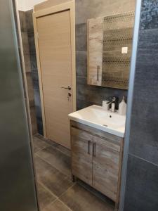a bathroom with a sink and a mirror at Ammos House Katakolo - by the sea in Katakolon +48 photos