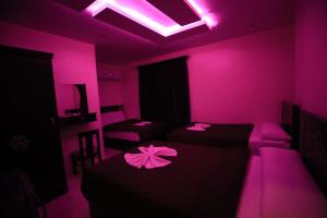 a room with two beds and a pink lighting at MagiC Pyramids INN in Cairo