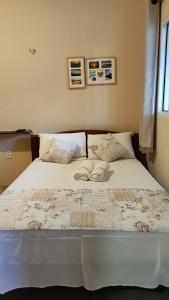 Un dormitorio con una cama con dos zapatos. en Casa de temporada 02 -Chalé Portal do Paraíso en Santo Amaro