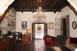 uma sala de estar com um lustre e uma porta em Mesón de la Abundacia em Real de Catorce