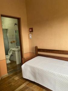 a bedroom with a bed and a bathroom with a toilet at Estrela da Serra Hotel Fazenda in Santo Antônio do Pinhal