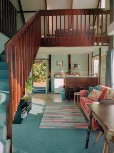 a living room with a staircase and a couch at Tokaanu Lodge Motel in Turangi