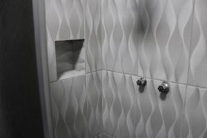 baño con ducha con un agujero en la pared en Hotel Cristo Rei, en Conceição da Aparecida