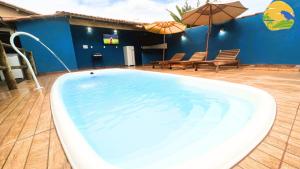 a large swimming pool with chairs and umbrellas at Casa Araras de Corumbau in Corumbau