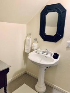 a bathroom with a white sink and a mirror at The Founders Suite at The Historic Kanab Inn in Kanab