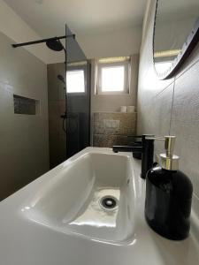 un lavandino in bagno con dispenser di sapone nero di APARTMENTS GRANČIĆ a Jelsa (Gelsa)
