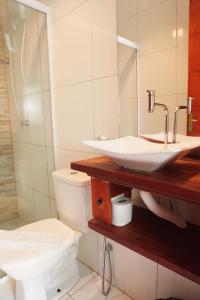 a bathroom with a sink and a toilet at Pousada Grand Fortim in Camocim