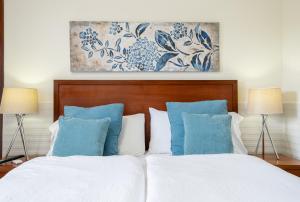 a bedroom with a white bed with blue pillows at Estalagem Pico D'Agua in Livramento