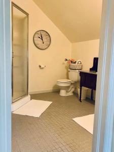 a bathroom with a toilet and a clock on the wall at The Founders Suite at The Historic Kanab Inn in Kanab