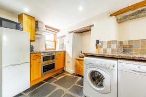 une cuisine avec laveuse et sécheuse dans l'établissement Cottontail Cottage, à Staveley