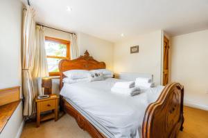 une chambre avec un lit avec des draps blancs et une fenêtre dans l'établissement Cottontail Cottage, à Staveley