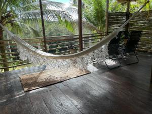 - un hamac sur un balcon avec 2 chaises et des palmiers dans l'établissement Ponta Poranga Jungle Lodge, à Manaus