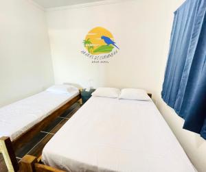 duas camas num quarto com uma placa na parede em Casa Araras de Corumbau em Corumbau