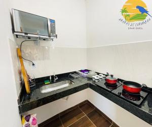uma pequena cozinha com um fogão e um lavatório em Casa Araras de Corumbau em Corumbau
