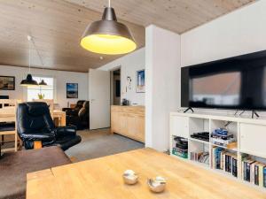 sala de estar con mesa y TV en 6 person holiday home in L kken, en Løkken