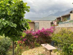 - une table de pique-nique dans un jardin avec des fleurs violettes dans l'établissement Holliday home 200m from the beach at White Rocks, Dhermi, à Dhërmi