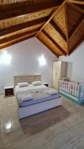 sypialnia z dużym łóżkiem i drewnianym sufitem w obiekcie Villa Skenderi w Sarandzie