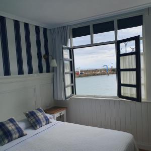1 dormitorio con cama y ventana en Hotel El Pescador, en Tazones