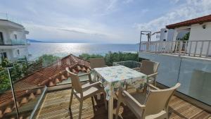 stół i krzesła na balkonie z widokiem na ocean w obiekcie Villa Skenderi w Sarandzie