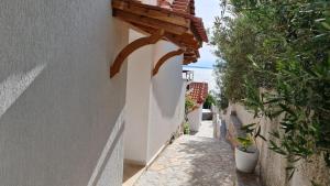 un callejón estrecho con plantas al lado de un edificio en Villa Skenderi en Sarandë