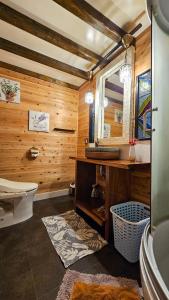 ein Badezimmer mit einem WC, einem Waschbecken und einem Spiegel in der Unterkunft Loft & Log House in Okayama