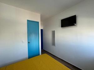 una camera con una porta blu e una TV a parete di Isla Venados Habitaciones Vacacionales a Mazatlán