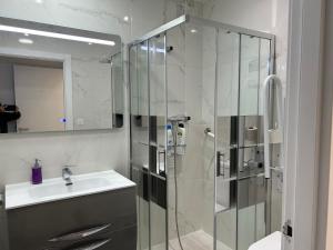 ein Bad mit einer Glasdusche und einem Waschbecken in der Unterkunft Wonderful room en suite in San Sebastián