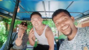 a group of three men sitting in a bus at navaa Bungalow in Phra Ae beach