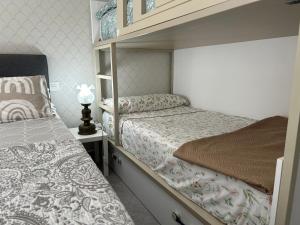 1 Schlafzimmer mit 2 Etagenbetten und einer Lampe in der Unterkunft Wonderful room en suite in San Sebastián
