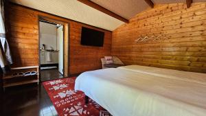 1 dormitorio con 1 cama en una pared de madera en Loft & Log House, en Okayama