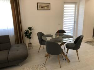 a dining room with a table and chairs and a couch at Comfort Residence Luxury Apartment in Craiova