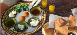 a table with a plate of food and some bread at Camp & Trek in Mhamid