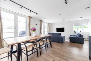a living room with a large wooden table and chairs at Arte Stays - Lux Stylish Penthouse - Heart of Wembley - Parking in London