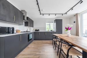 a kitchen with a wooden table and a wooden floor at Arte Stays - Lux Stylish Penthouse - Heart of Wembley - Parking in London