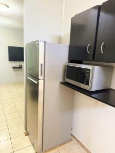a kitchen with a stainless steel refrigerator and a microwave at Descanso Esencial Azul - 7 Min Malecón y Playas in Mazatlán